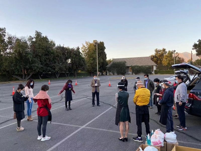 疫情期间弟兄姊妹在户外停车场围成一圈祷告