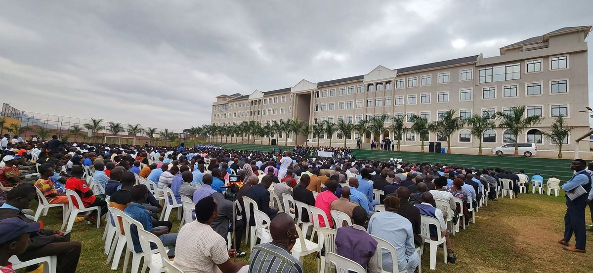 A thousand people seated on the grass in front of the new building on dedication day