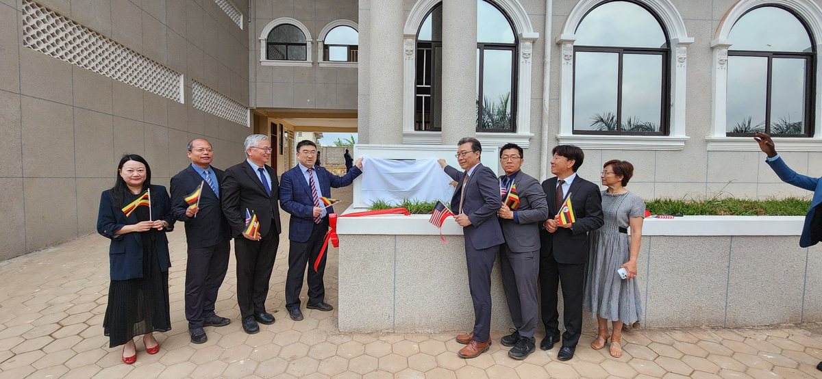 Several people together lifting the cloth from a dedication stone