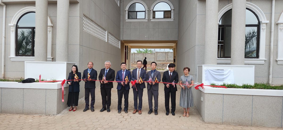 Guests holding a red ribbon in front of the newly finished seminary building