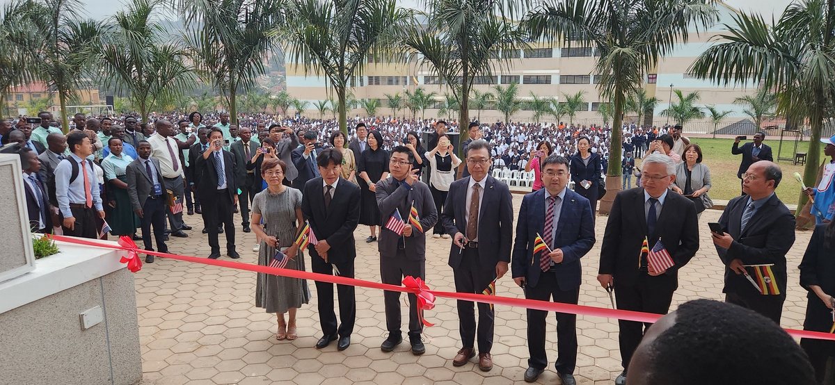 A ribbon cutting at a new campus in Uganda, the grounds full of students and guests